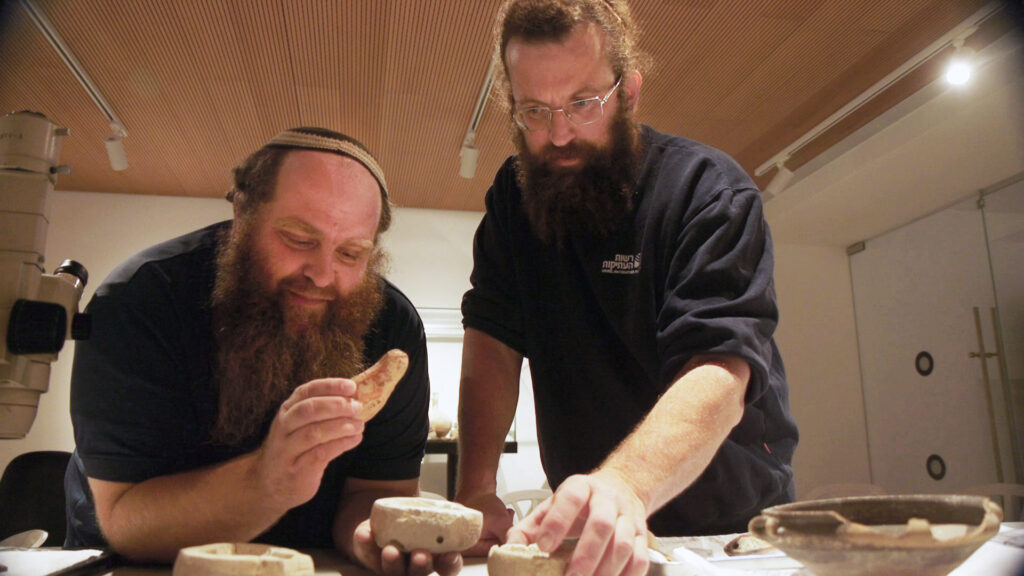 החוקרים מיכאל טשרנין ובנימין סטורצ'ן בוחנים את הנר. צילום אמיל אלג'ם 